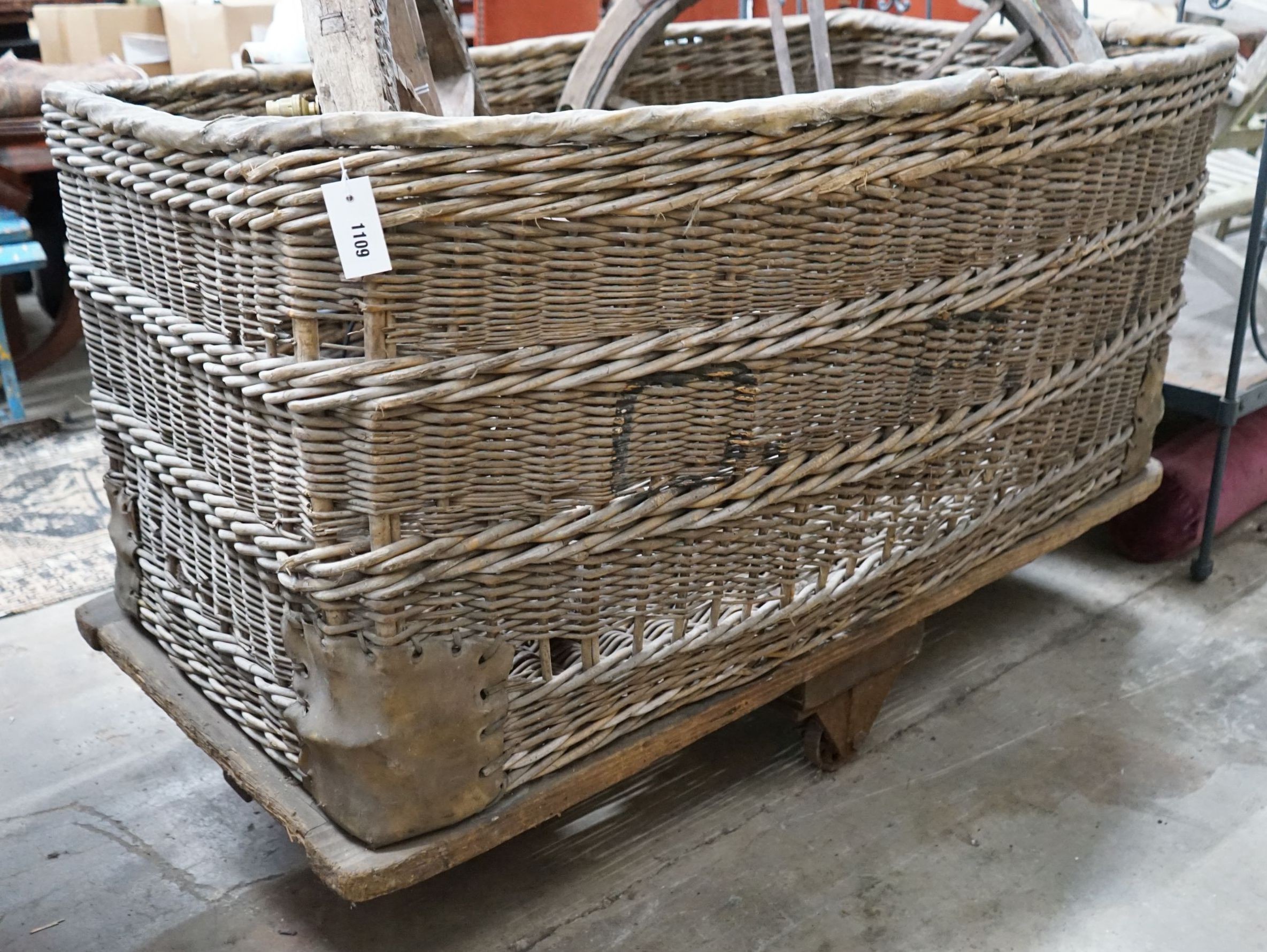 A large vintage wicker laundry basket on wheeled base, length 133cm, width 89cm, height 87cm